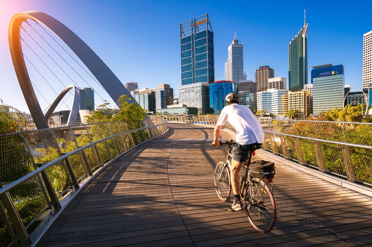 A man cycling on an elizabeth bridge in Perth city, western