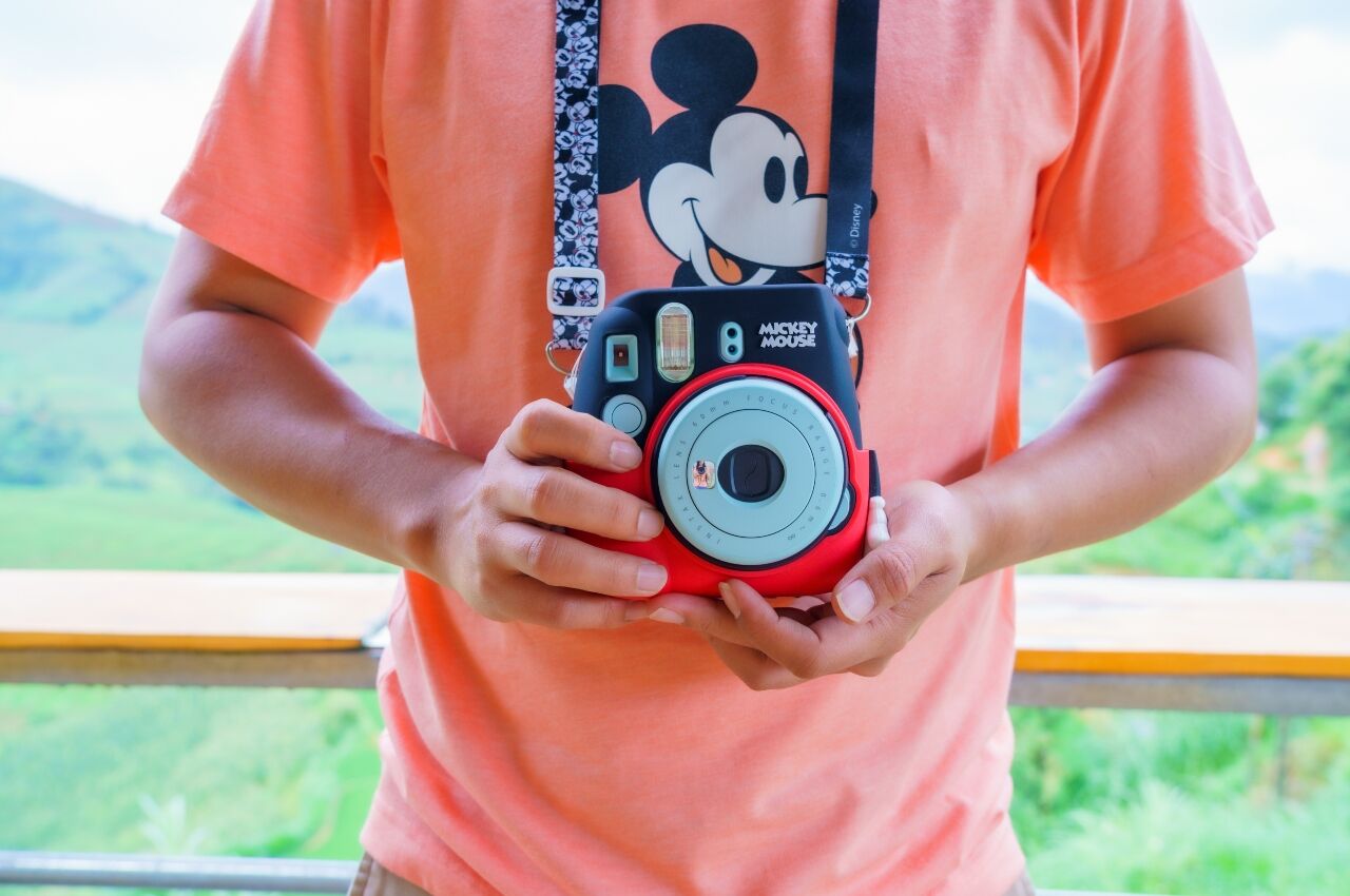 Kid with Disney-themed camera and t-shirt 