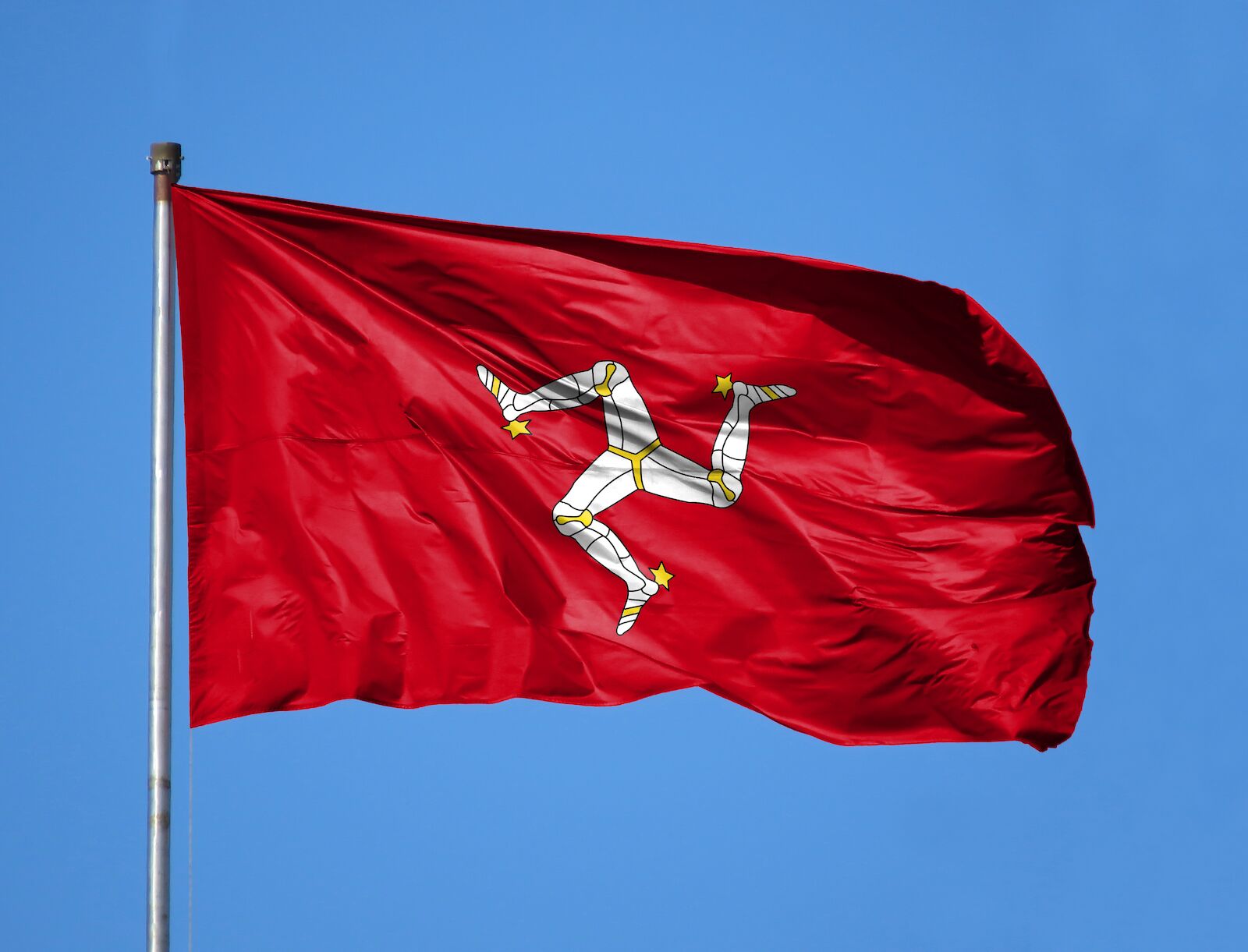 Celtic flags: The Isle of Man. The flag of the Isle of Man is red with a triskelion of three legs with golden spurs