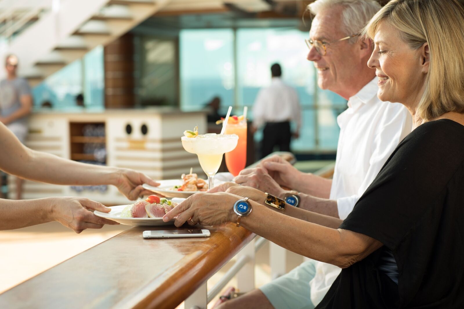 Couple at bar with cruise line drink packages and food 