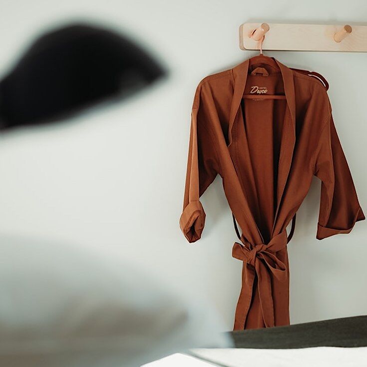 Local mademade robe hangs in bedroom at Hotel Dryce