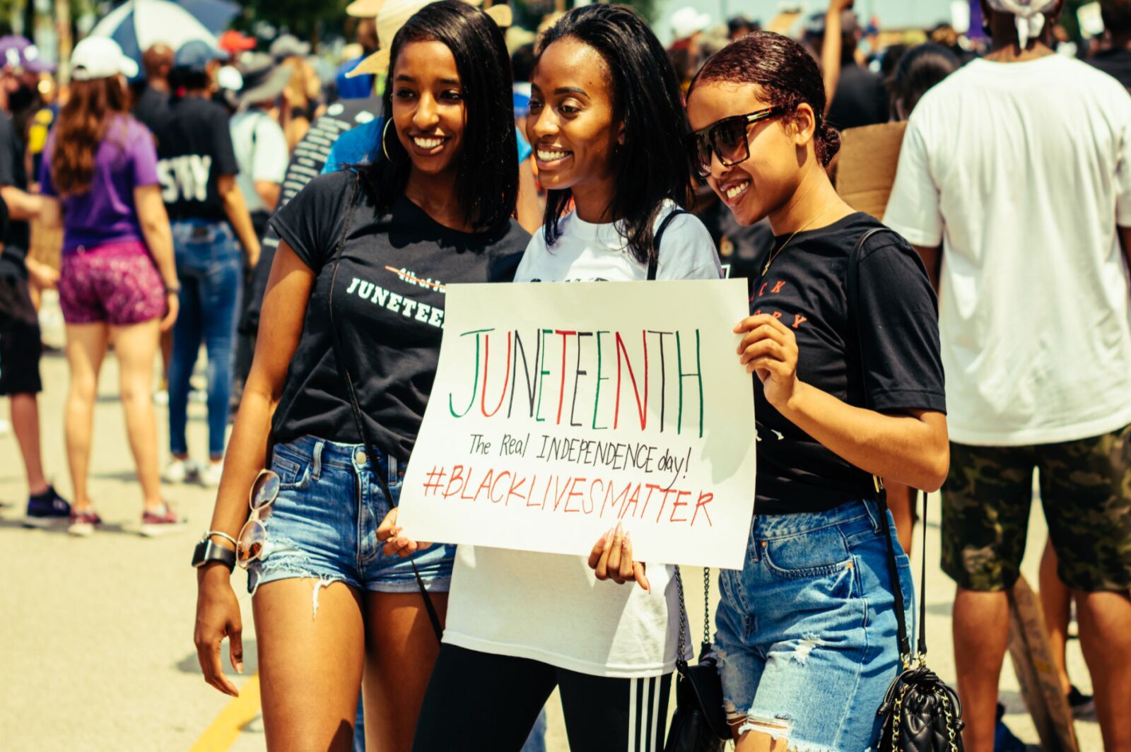 Black women holding up Juneteenth sign