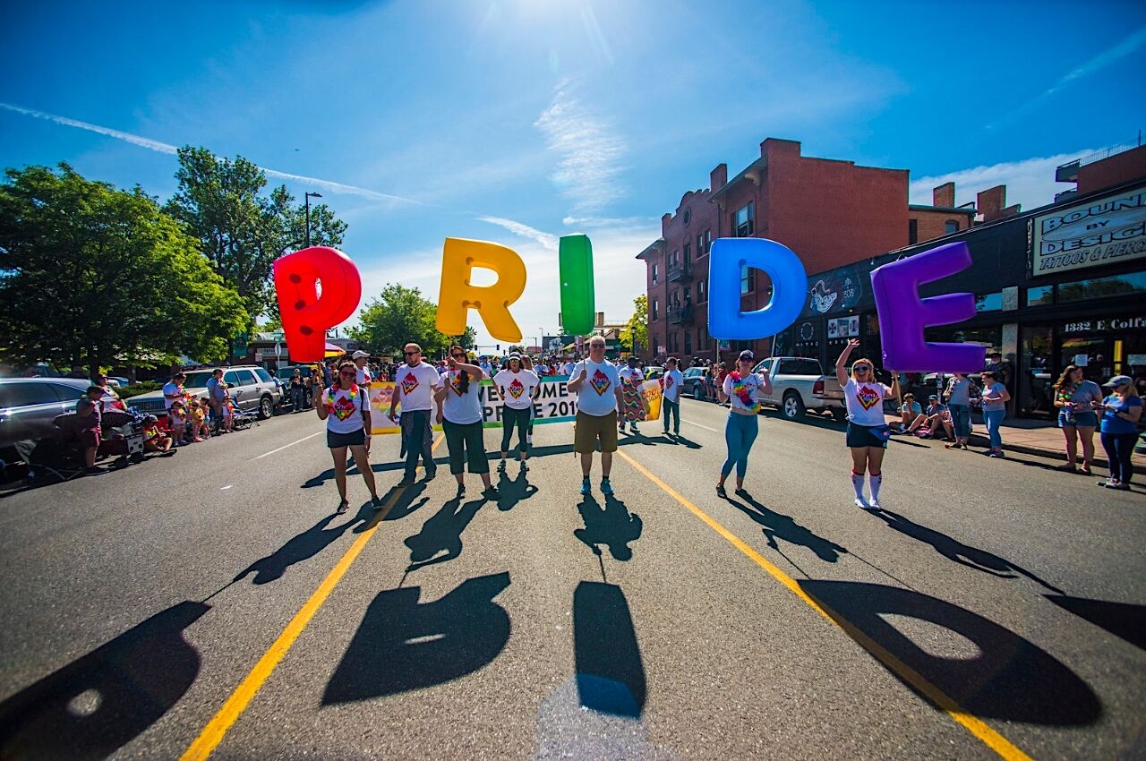 People walk with Pride sign in Denver