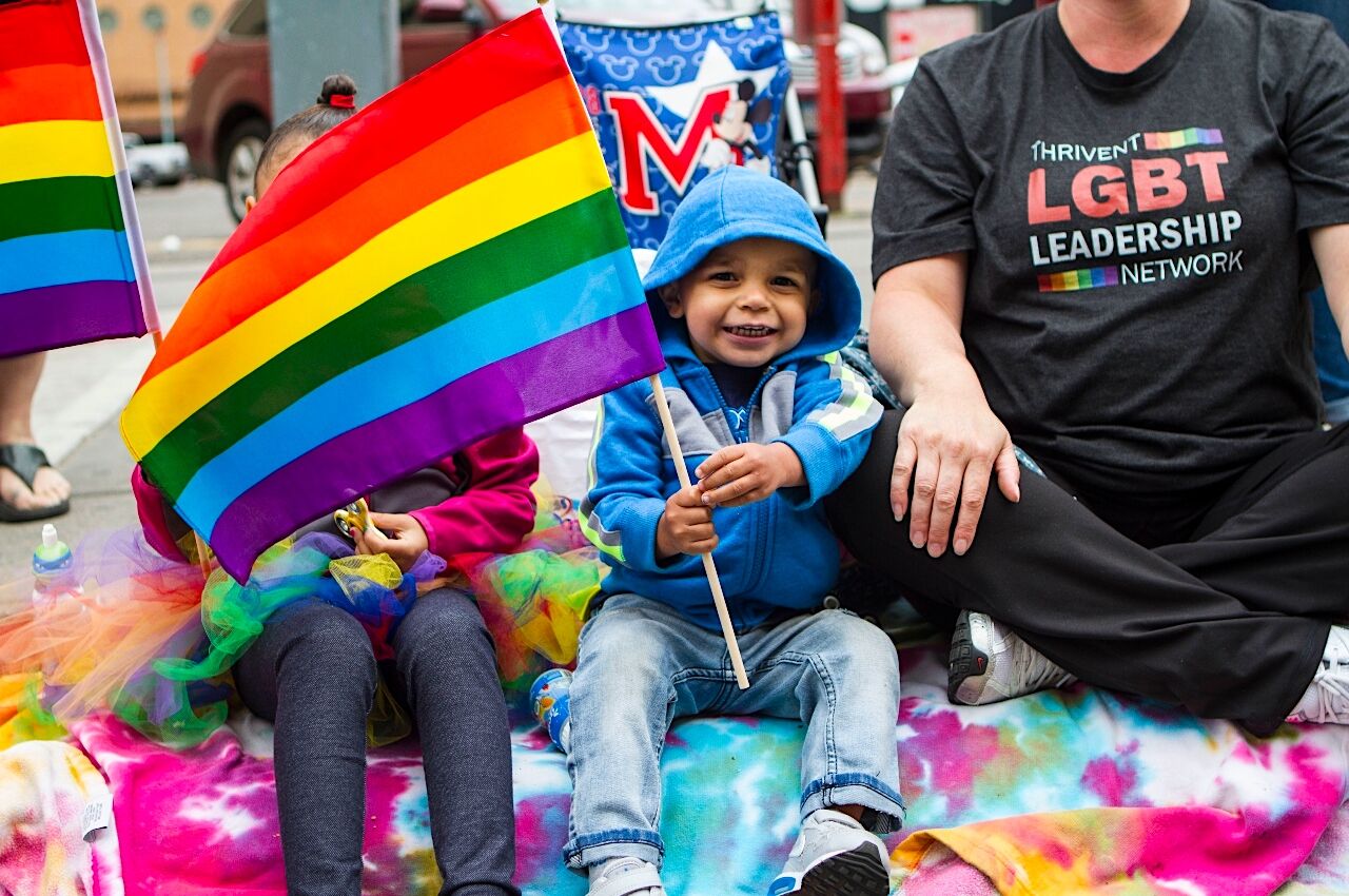 Child holds rainbow flat at Twin Cities Pride