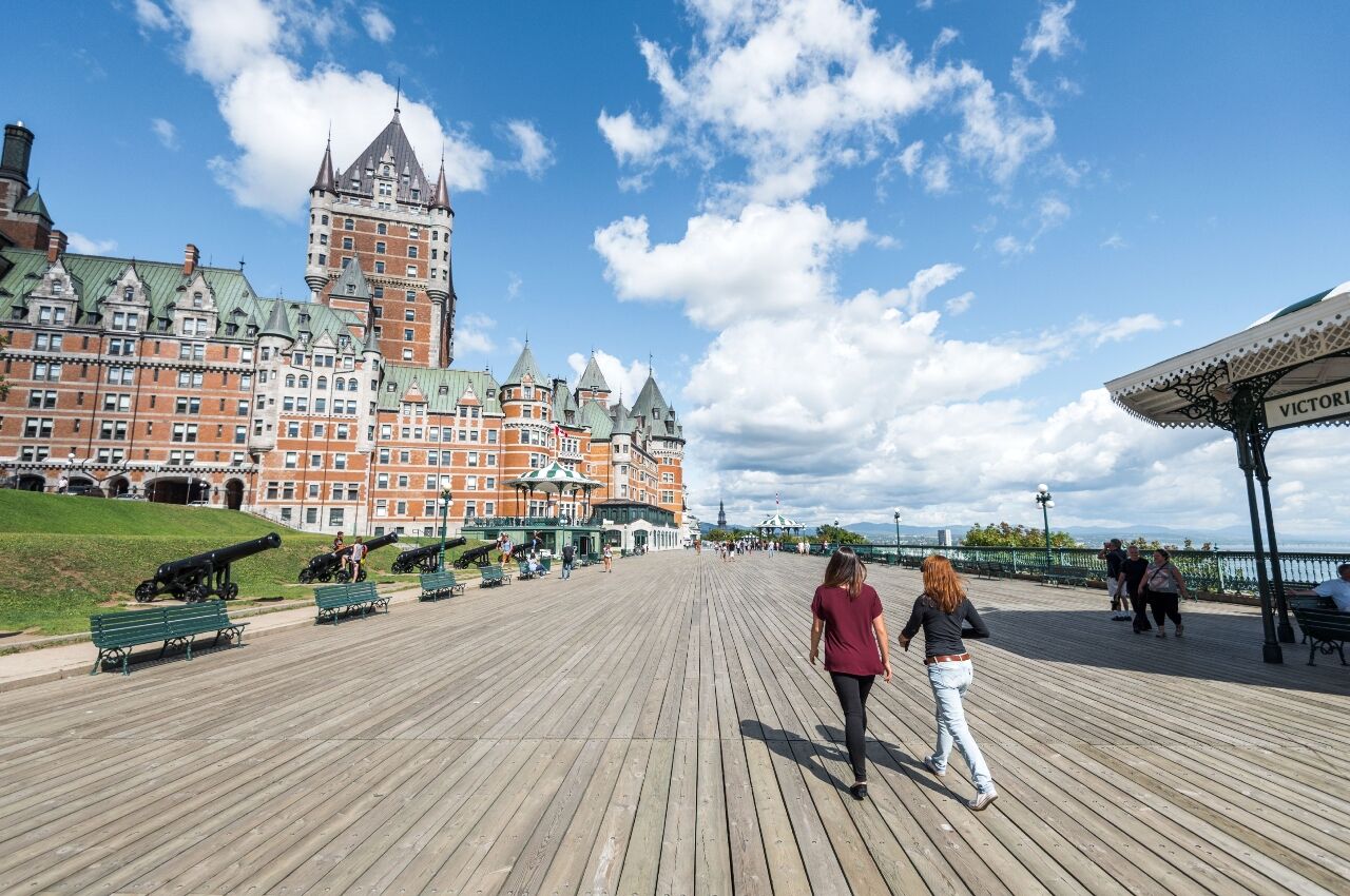 Couple walking on the boardwalk in Quebec in summer one of the cheap summer vacations