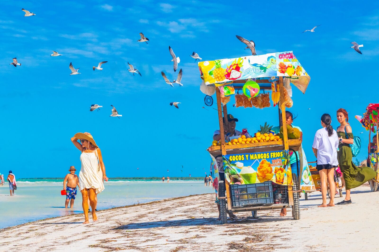 Holbox Mexico 21. December 2021 Fruit and mango seller on beautiful Holbox island sandbank and beach with waves turquoise water and flying seagulls birds in Quintana Roo Mexico.