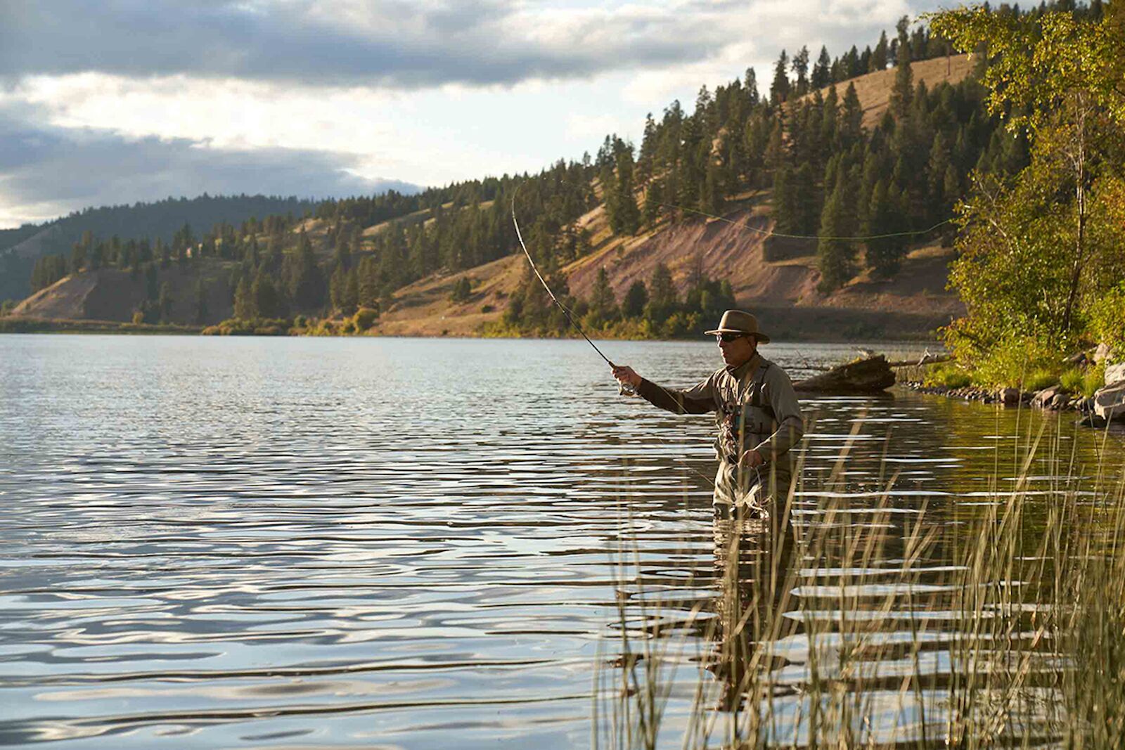 man fly fishing alone in the river in montana