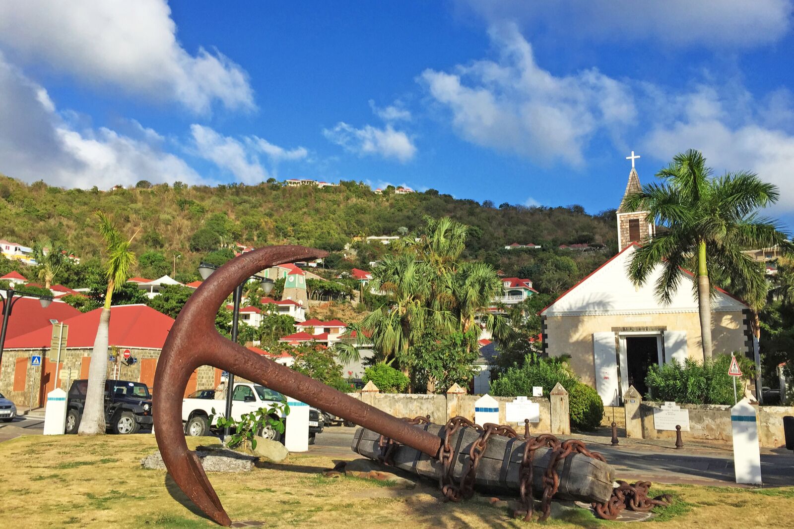 large, rusted anchor in front of a church