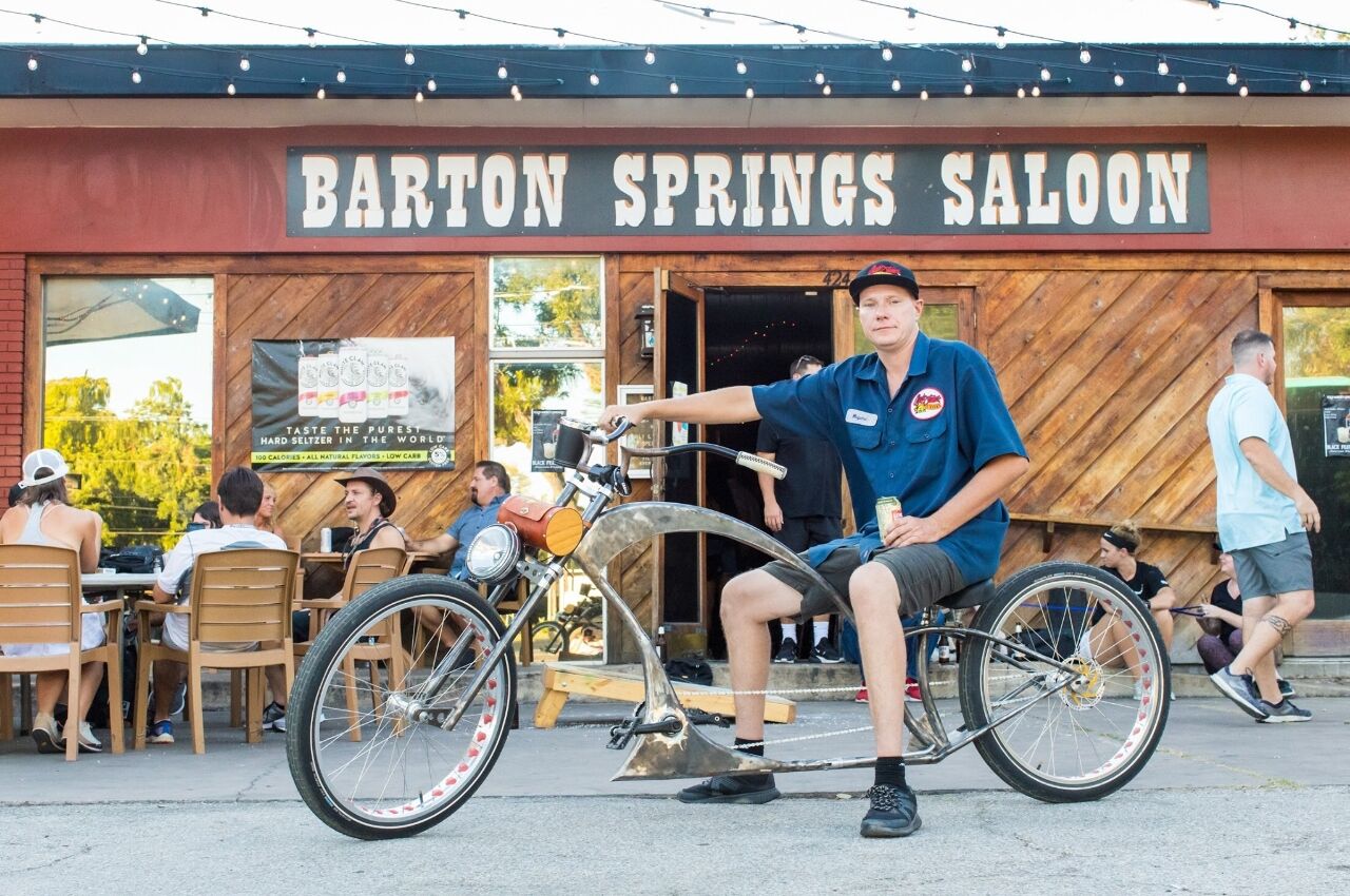 Man on bike outside Barton Springs Saloon