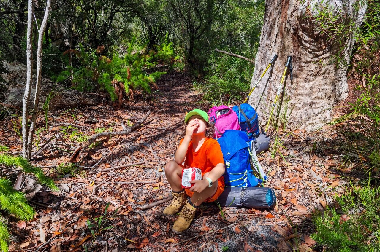 Young boy with backpack on over night hike