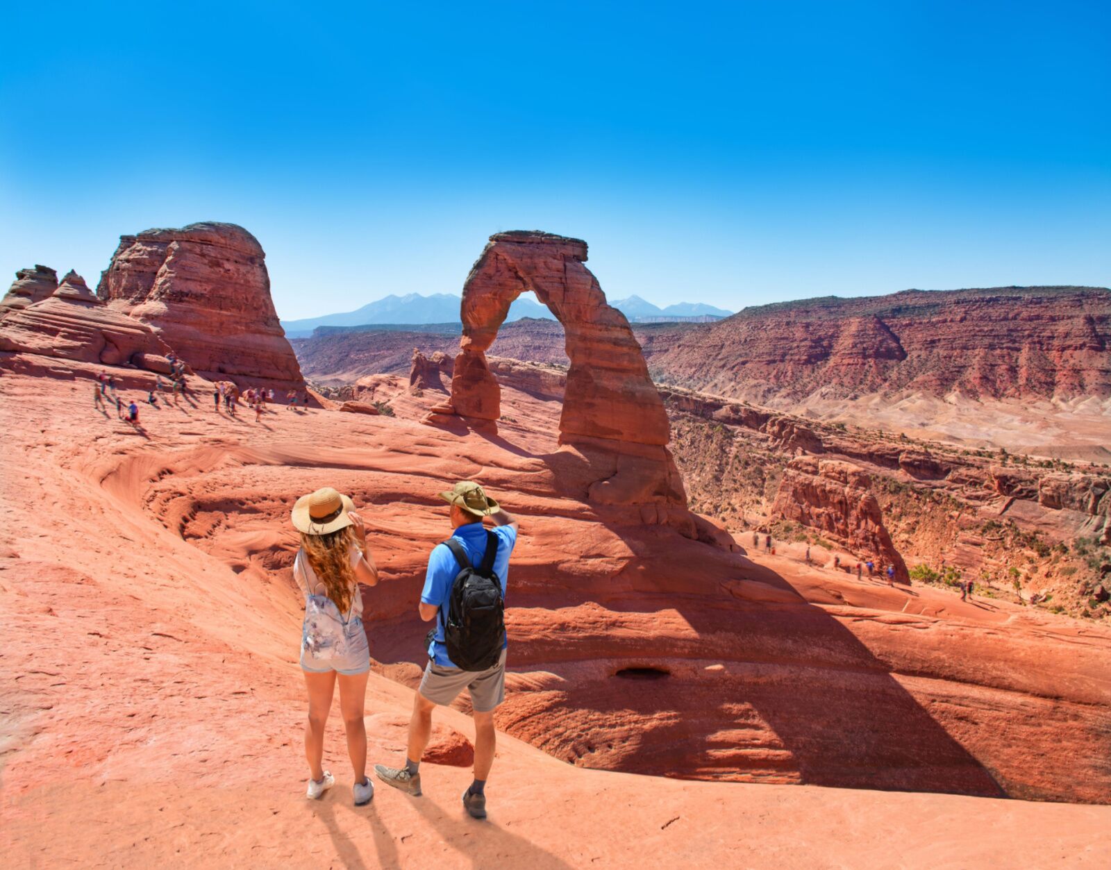 Two people hiking at arches on beacation