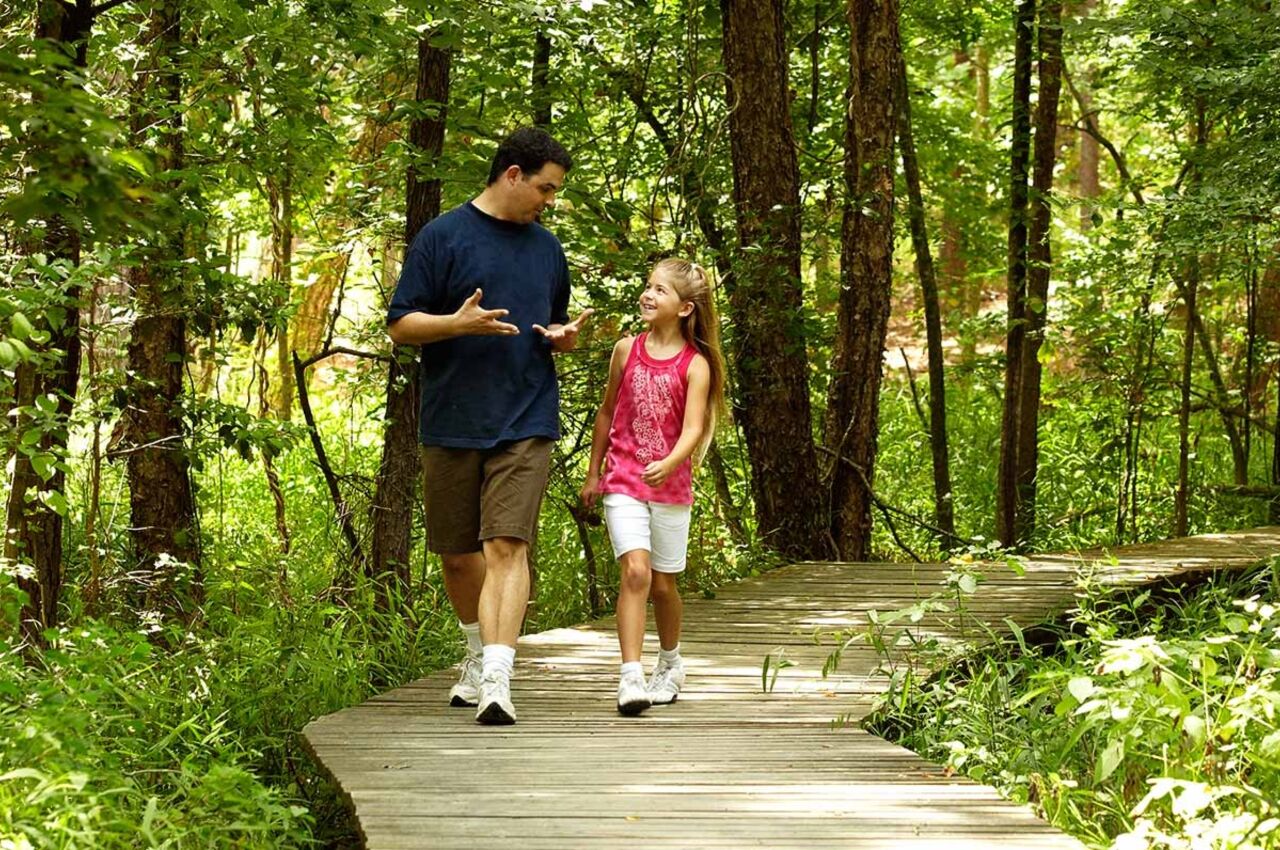 Man and girl walk in woods at Huntsville one of the best state parks in texas