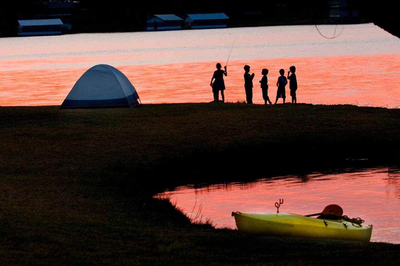 Sunset and group of people near tent at at ink Lake a state park in texas