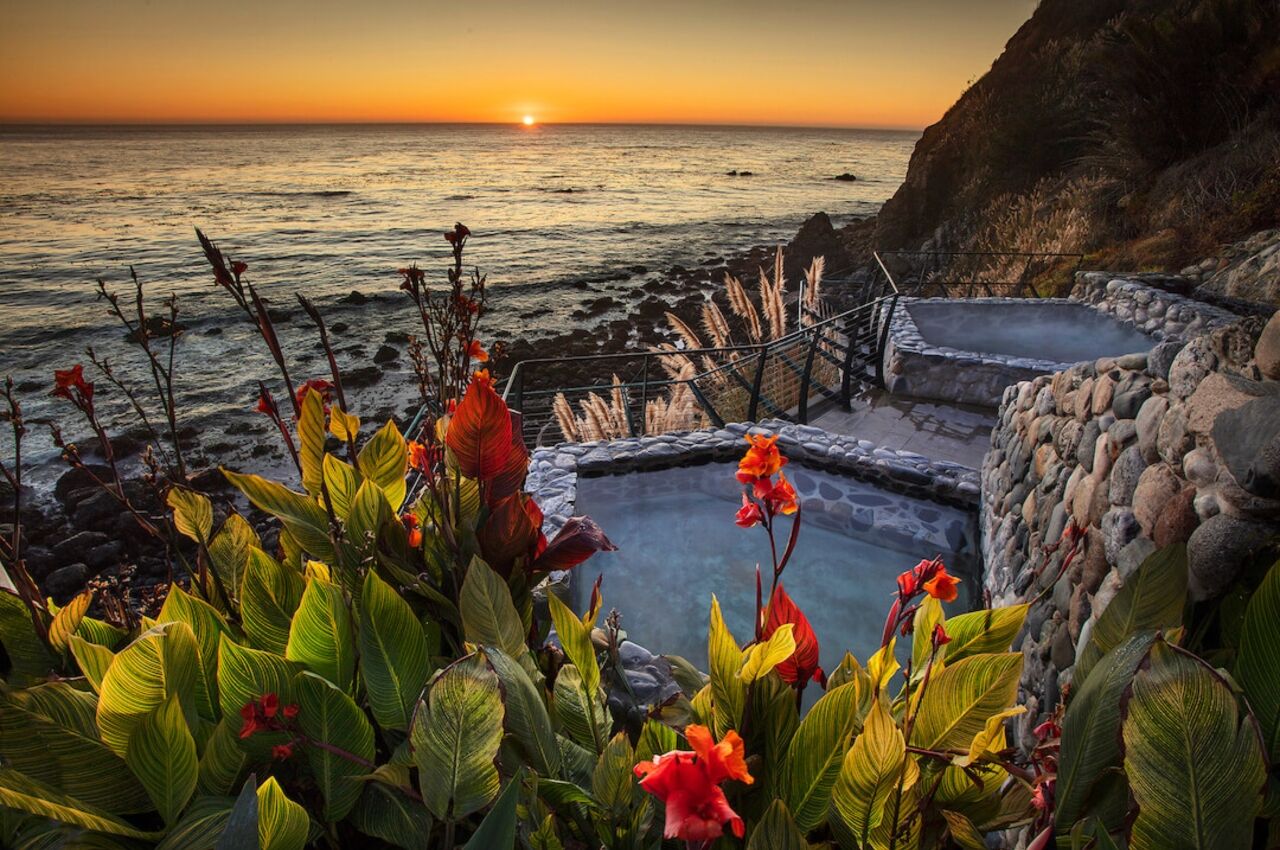 View over outdoor pools at sunset at tantric retreat Esalen Institute