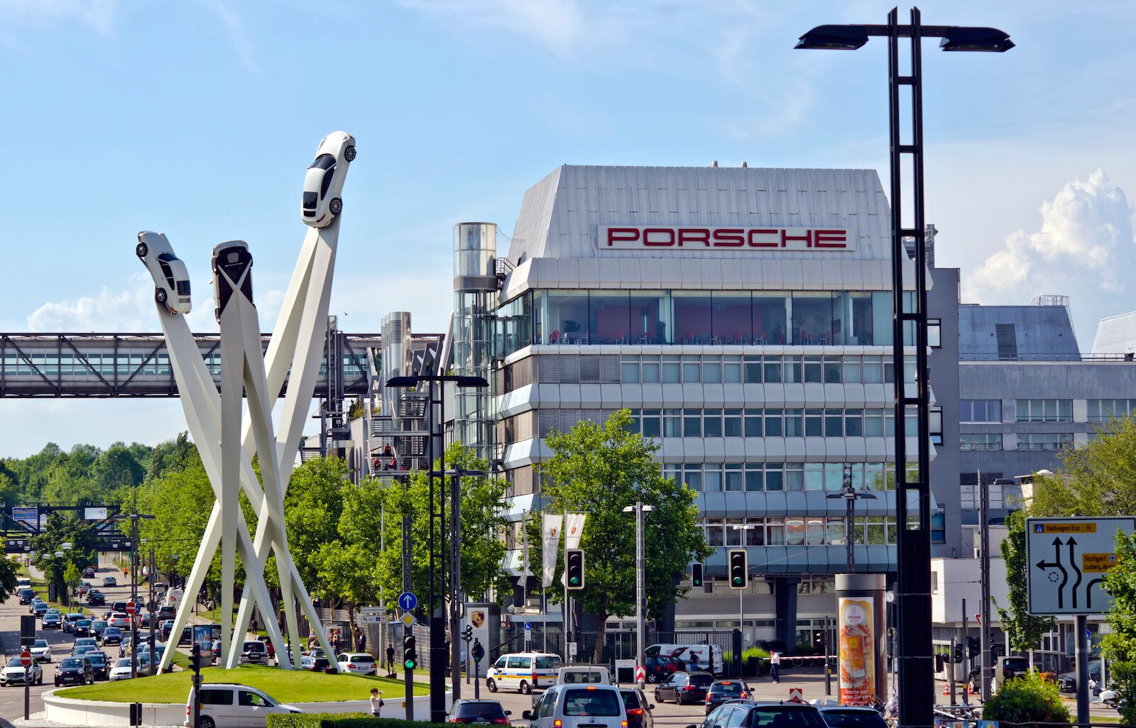 STUTTGART- ZUFFENHAUSEN, GERMANY - JULY 6, 2017: Porscheplatz, where is located a futuristic sculpture composed of three iconic generations of the Porsche 911 model, in front of Porsche Factory.