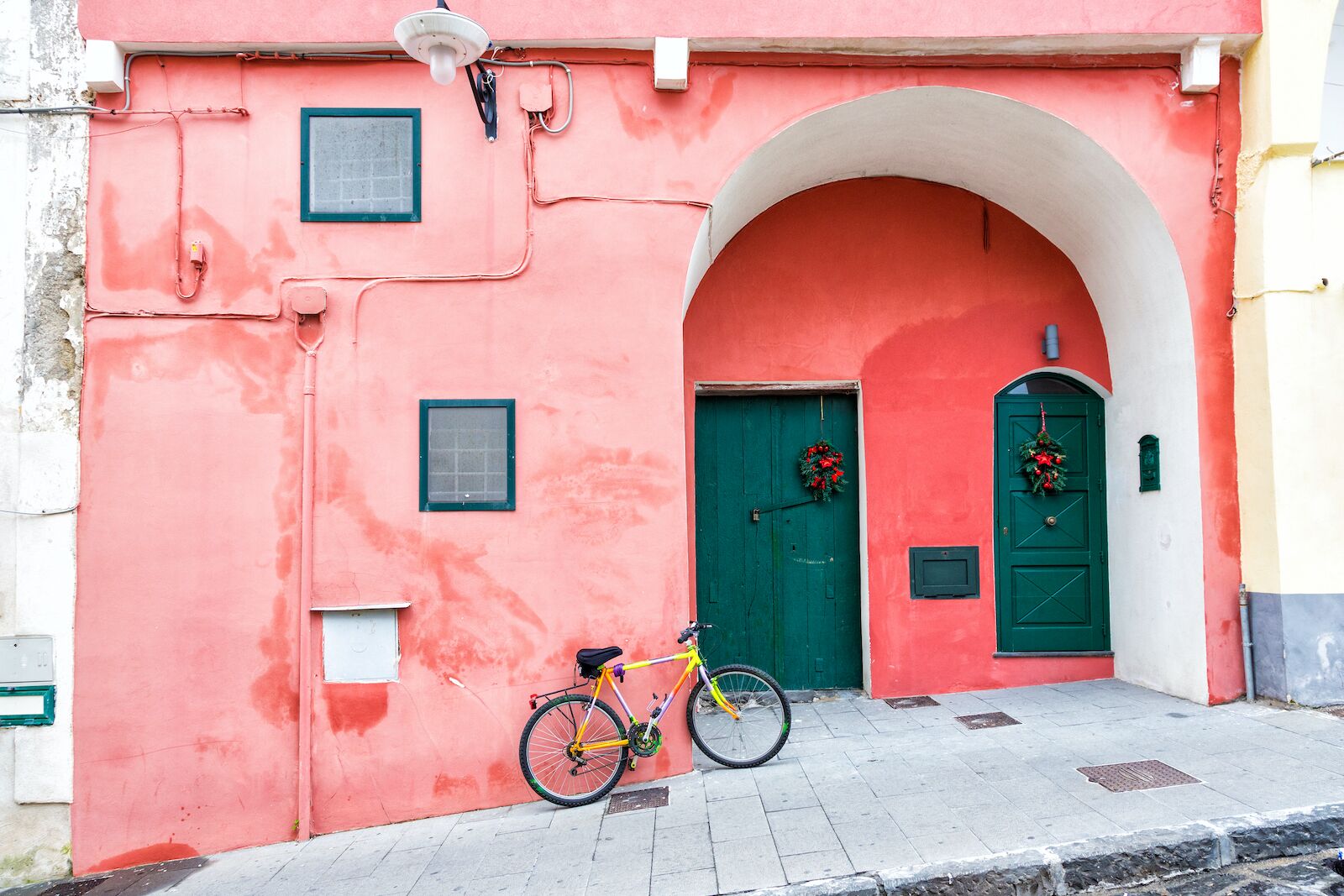 bike leaning up against a big wall in procida france one of the happiest countries in the world