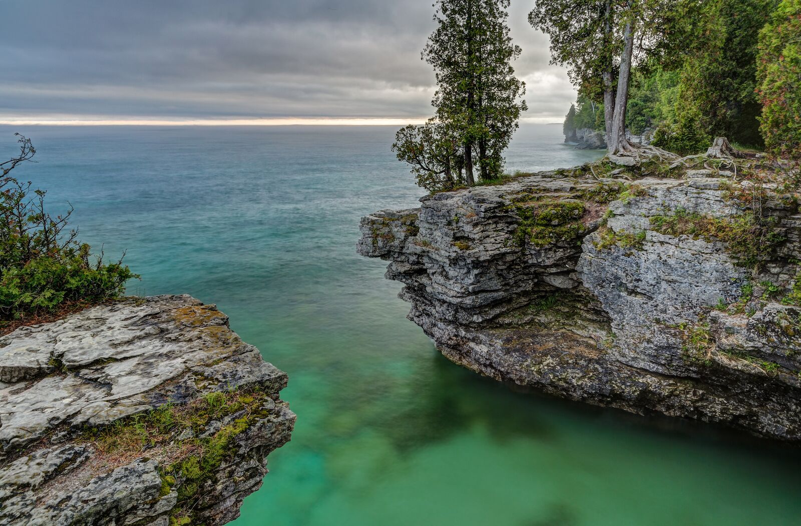 The rocky coast of Door County, Wisconsin's Cave Point displays beautiful colors in the light of a stormy sunrise.