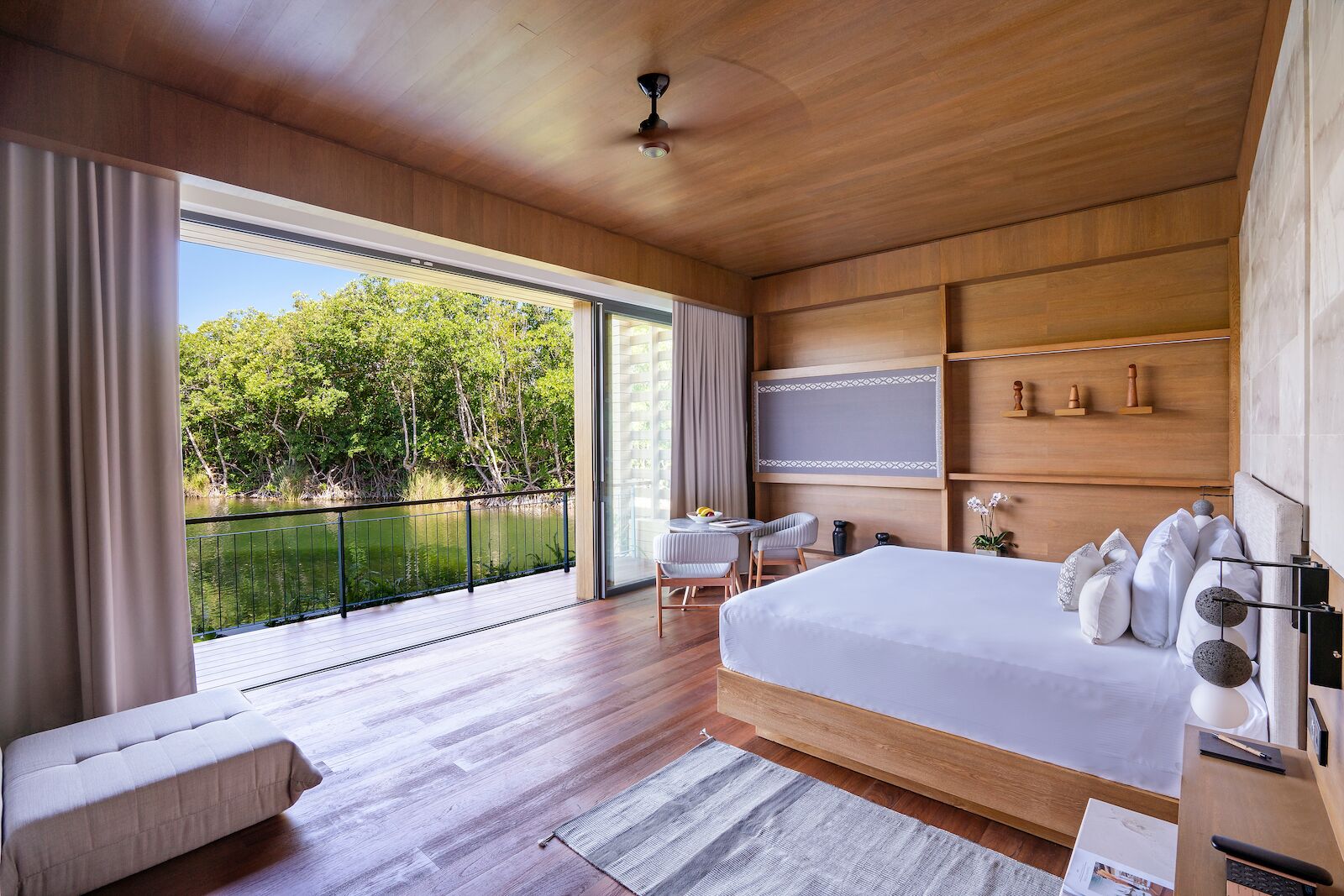 Lagoon villa master bedroom with terrace and view of the water at the banyan tree mayakoba