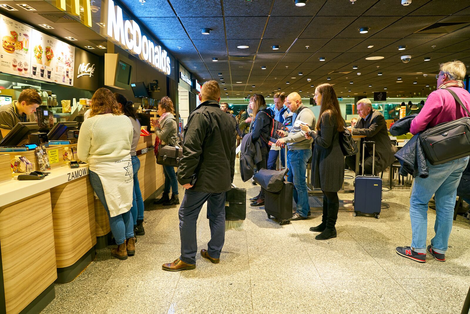 A long line at McDonald's counter in an airport in Poland
