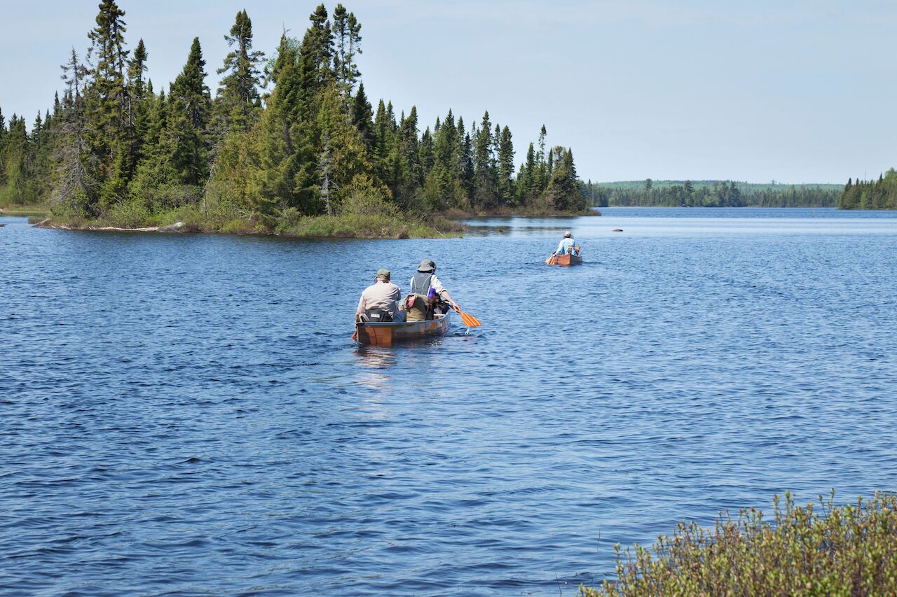 LUTSEN, MINNESOTA, USA - JUNE 7, 2019: Senior campers head out in a canoe on a northern Minnesota lake with their guides for a Boundary Waters camping trip