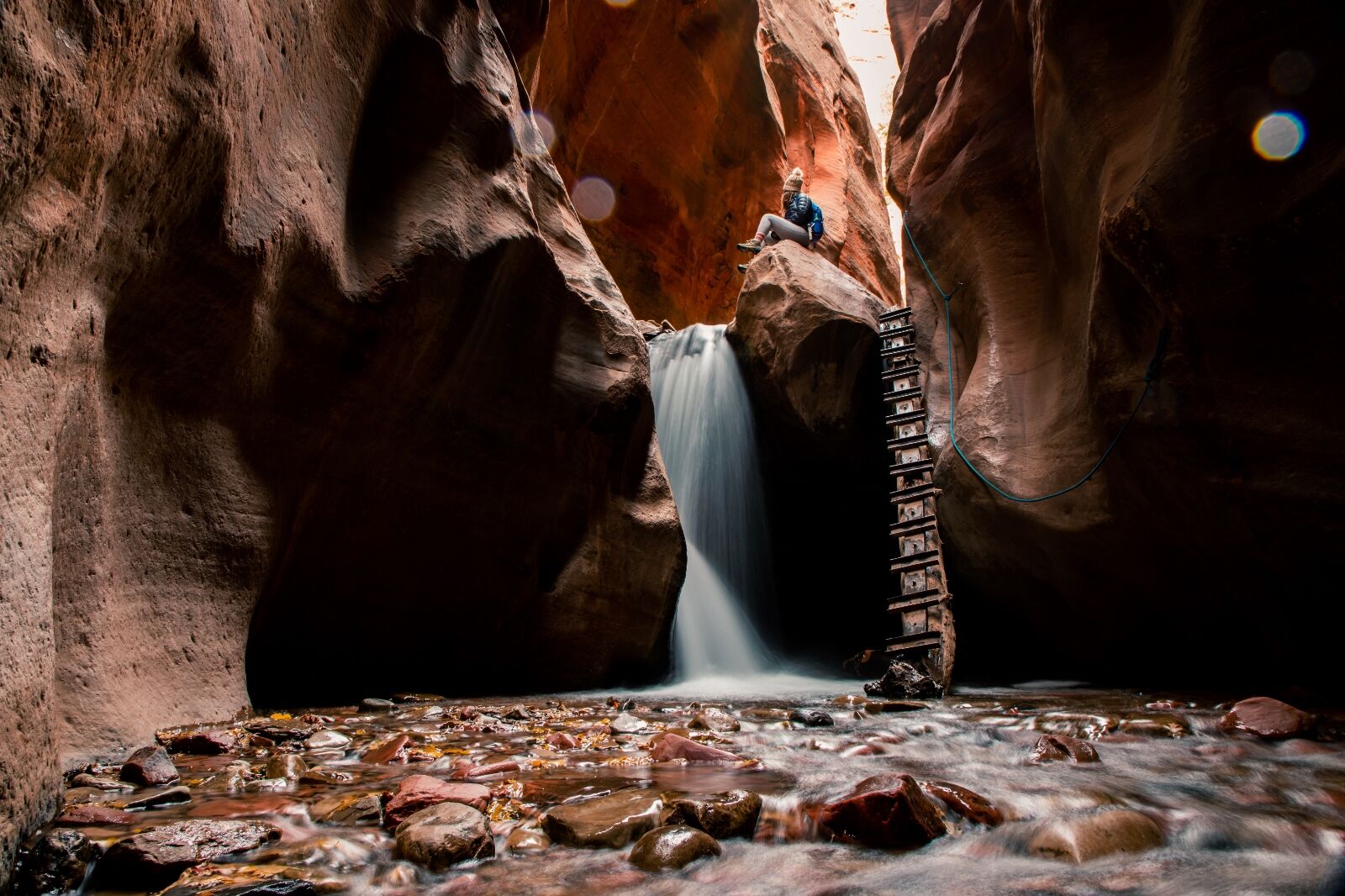 Hiker sits at Kanarra Falls one of the many waterfalls in Utah 