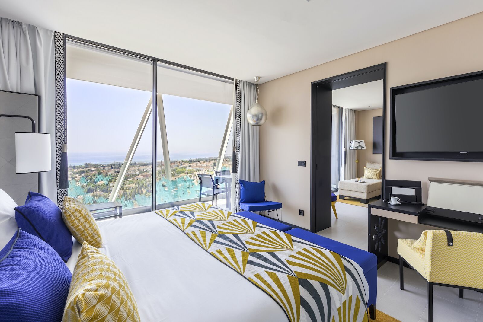 A suite a Club Med Magna Marbella with a view of the town, terrace, large television, and bed