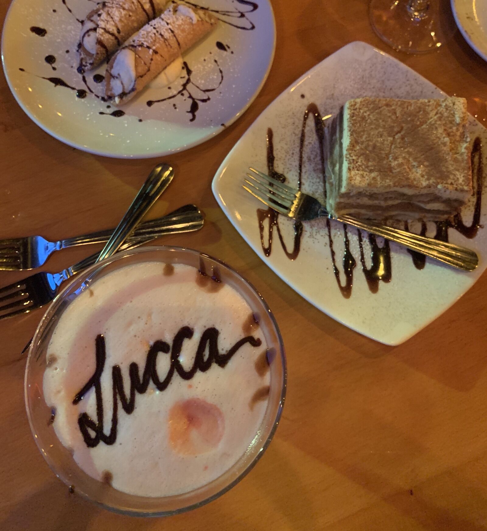 Cannolis, a coffee with foam, and tiramisu at one of the best Italian restaurants in Pittsburgh, called Lucca Ristorante