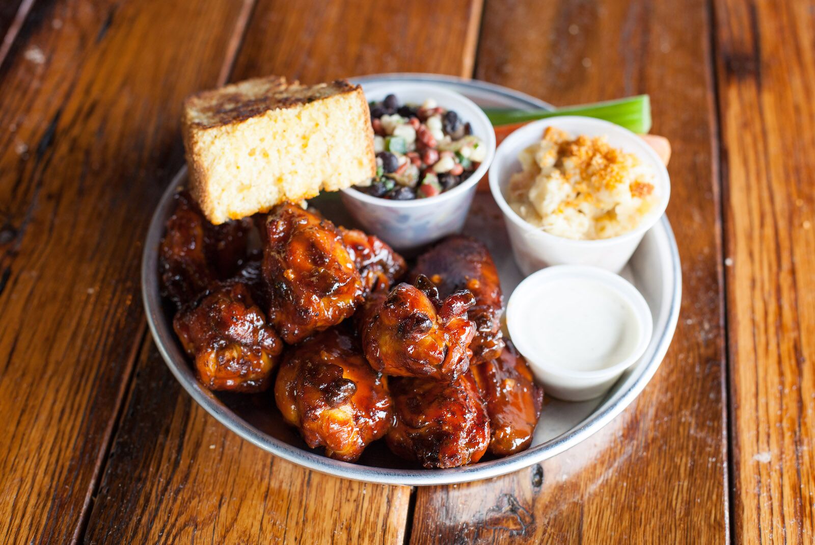 a platter of wings, topped with a slice of cornbread, at Edley's, where to go for the best bbq in Nashville