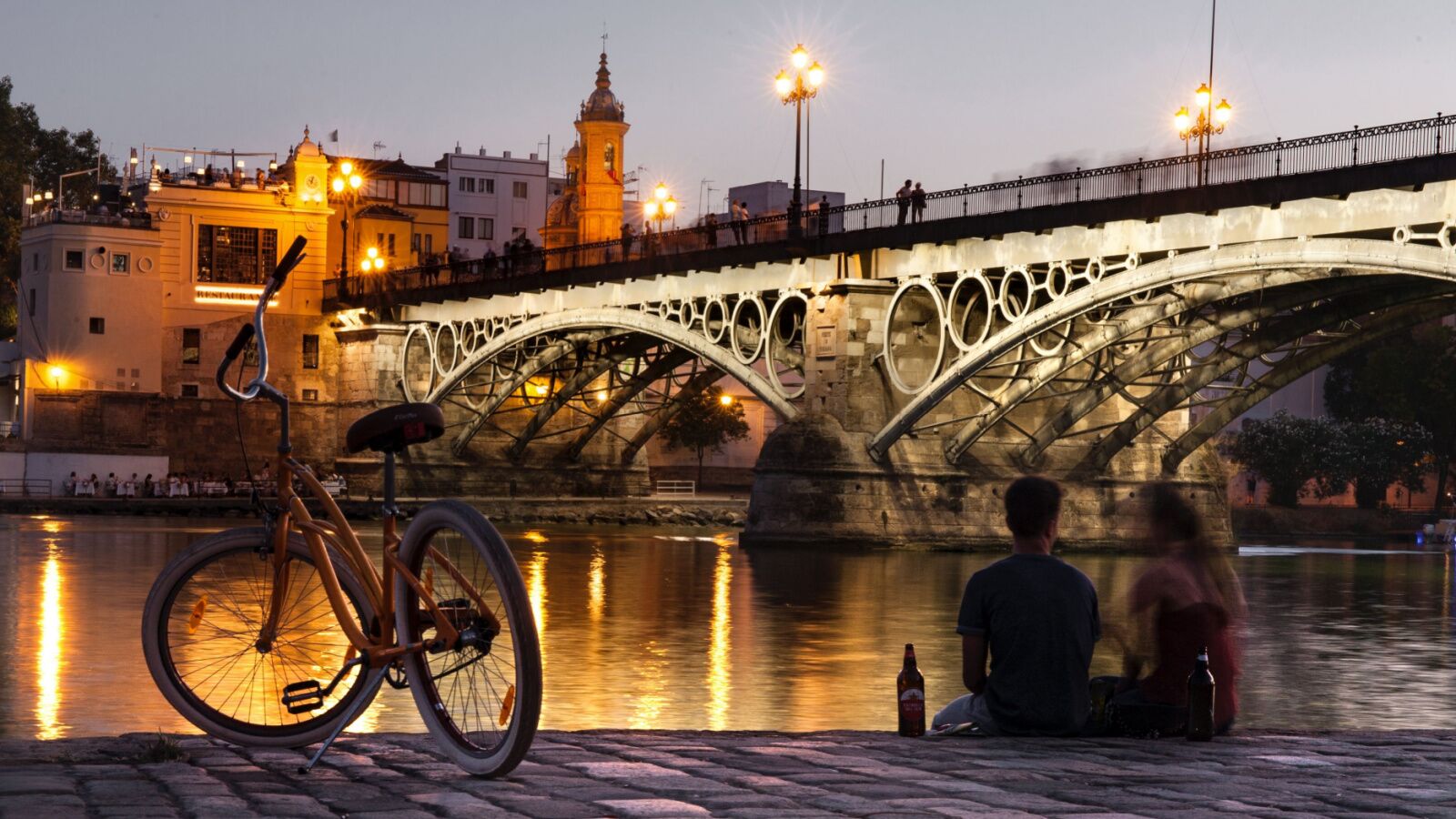 Couple and a bicycle next to the river in Seville, Spain