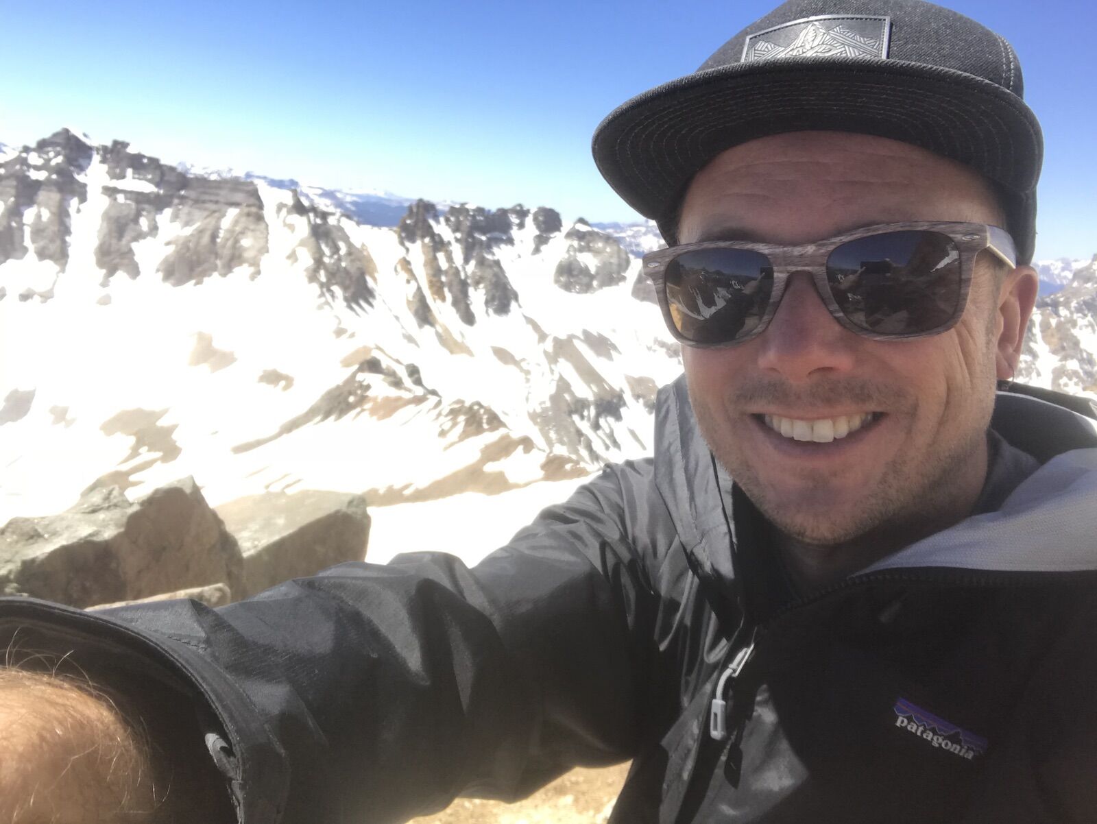 man on mountain in patagonia torrentshell jacket
