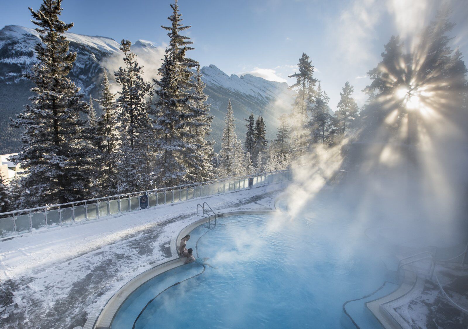 Two people relaxing in a hot spring during a banff winter wellness weekend 