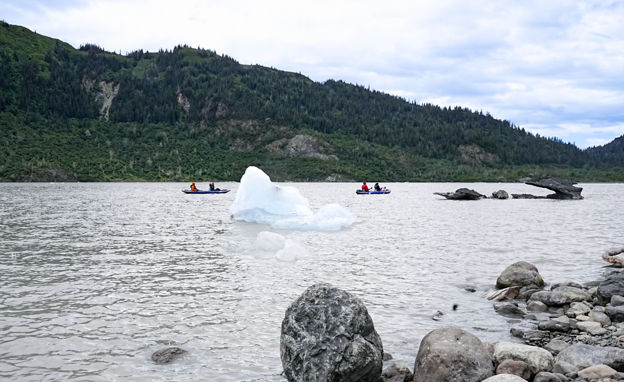 kayakers on the water near a glacier at Stillpoint Lodge, alaska