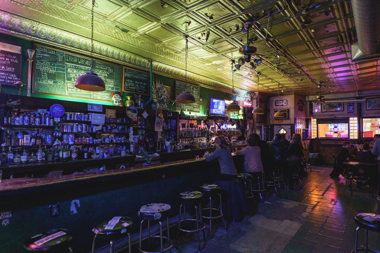 L&L dive bar Chicago interior with patrons at the bar and green lights 