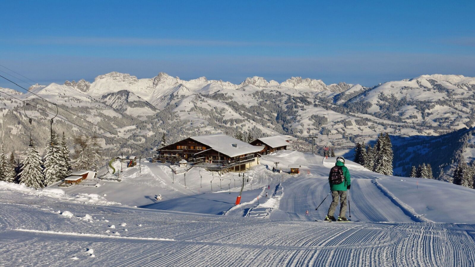 Gstaad is one of the best ski resorts in the alps for beginners. skier going down an easy groomed slope