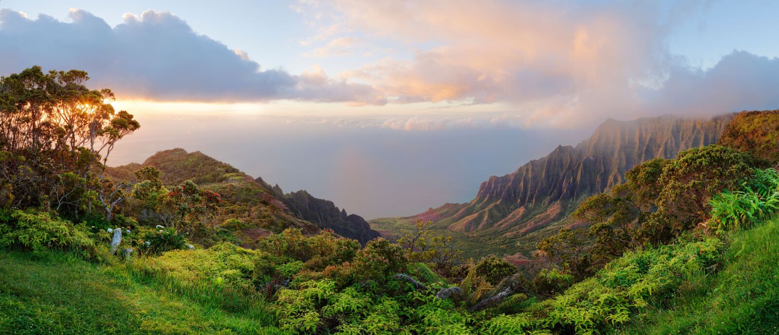 Kalalau lookout panorama on Hawaii island Kauai. Beautiful color sunset with rainy clouds. View of the Kalalau Valley and Na Pali coast