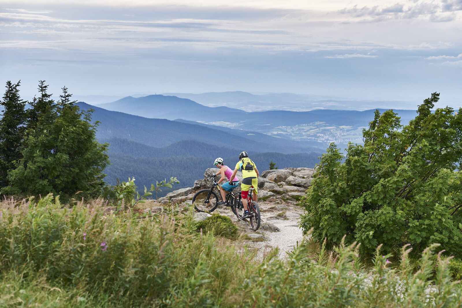 two people about to send it while biking in the bavarian forest
