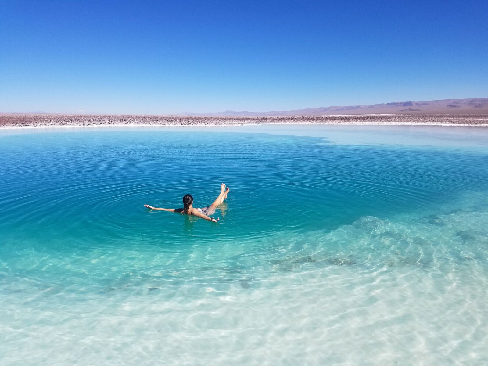 Woman floating in a natural salt pool in chile