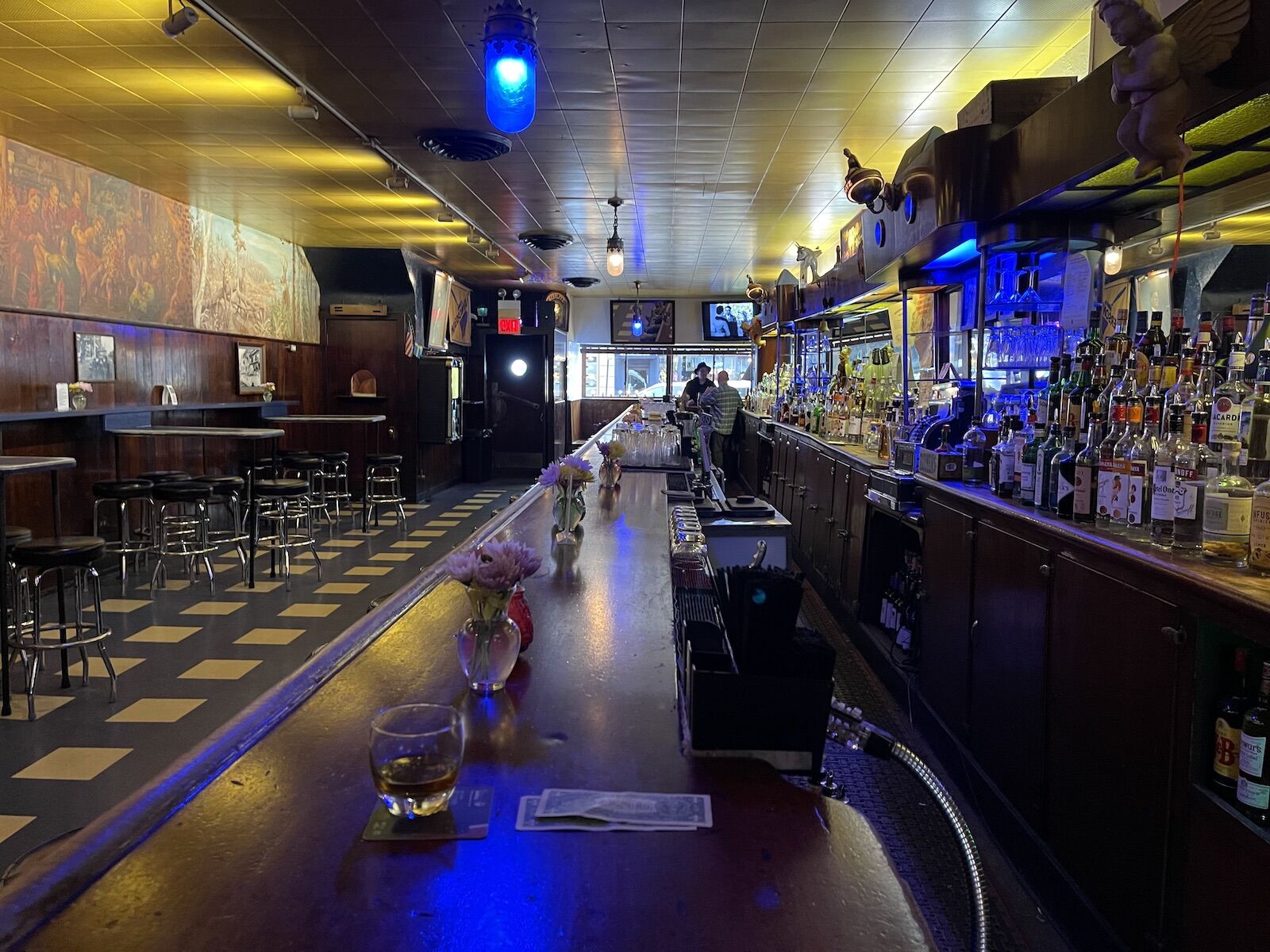 Simons dive bar Chicago with black and white tiled floors, bar, and bar stools 
