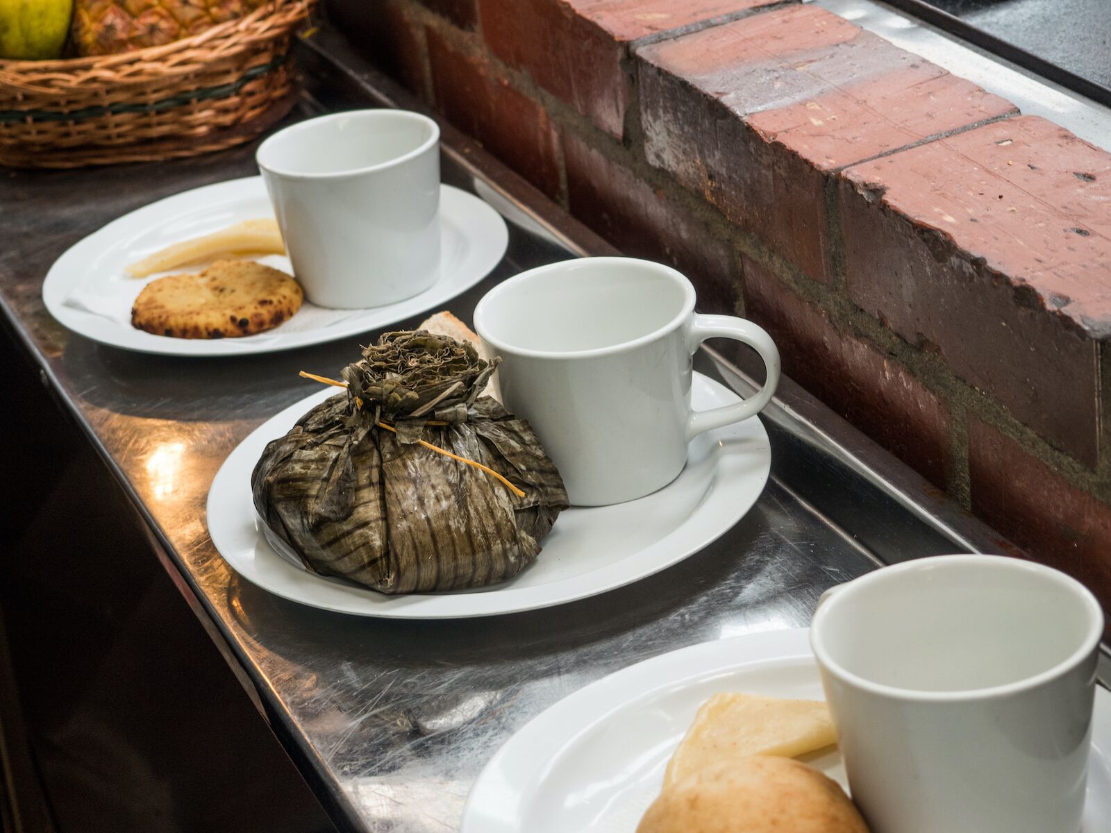 A common Colombian breakfast food is a tamal wrapped in a plaintain leaf served wtih a cup of a coffee