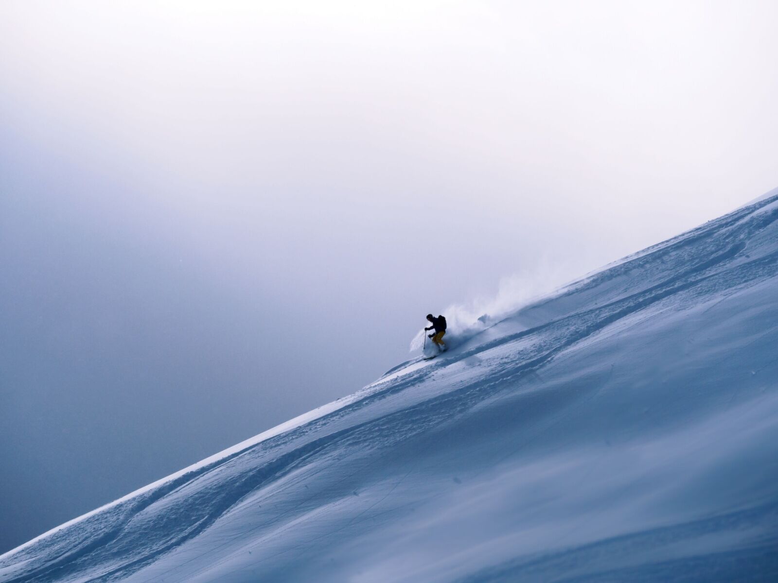 skier headed down a steep slope at verbier switzerland, one of the best alps ski resorts
