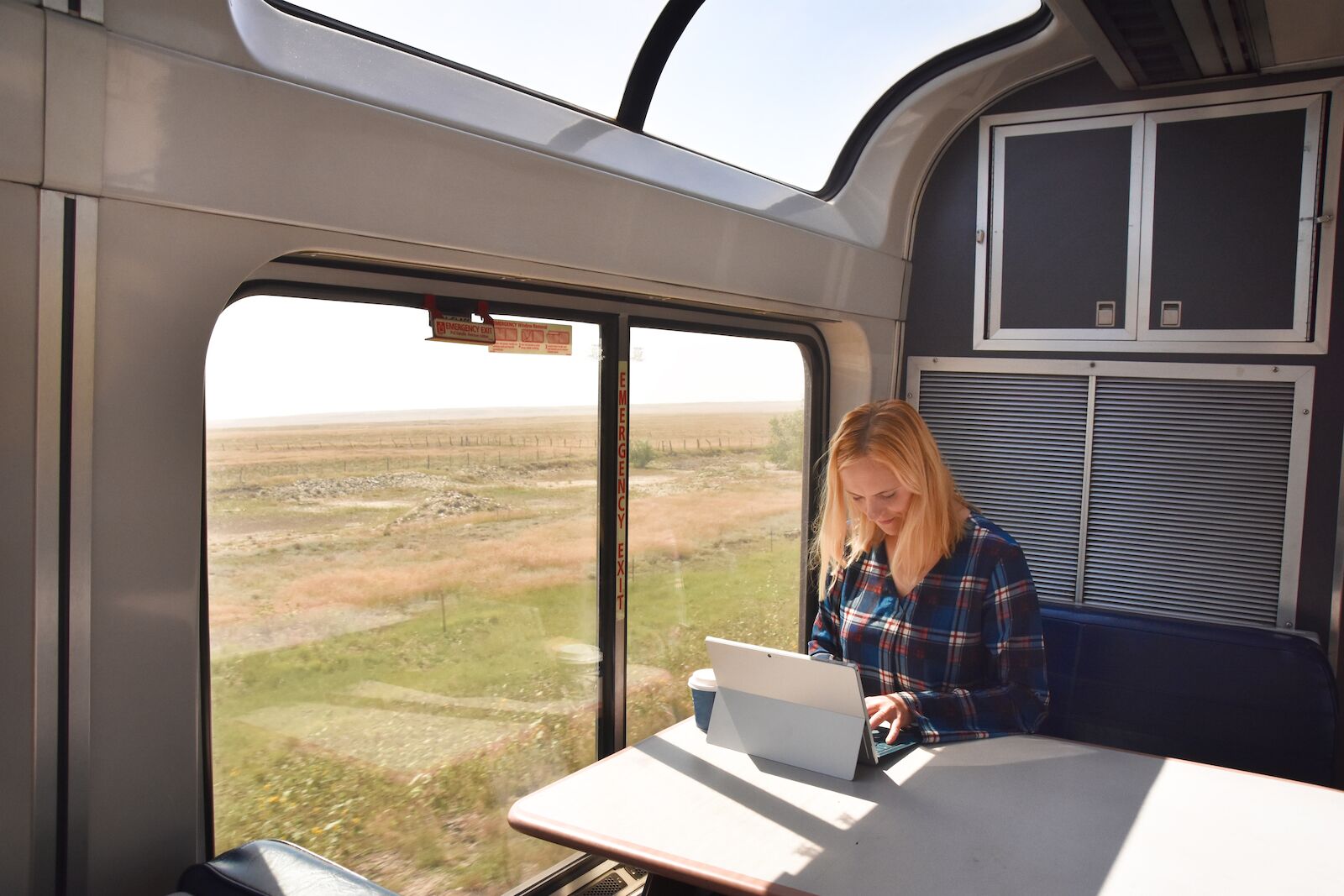 Woman using a tablet on a train using Amtrak's WiFi