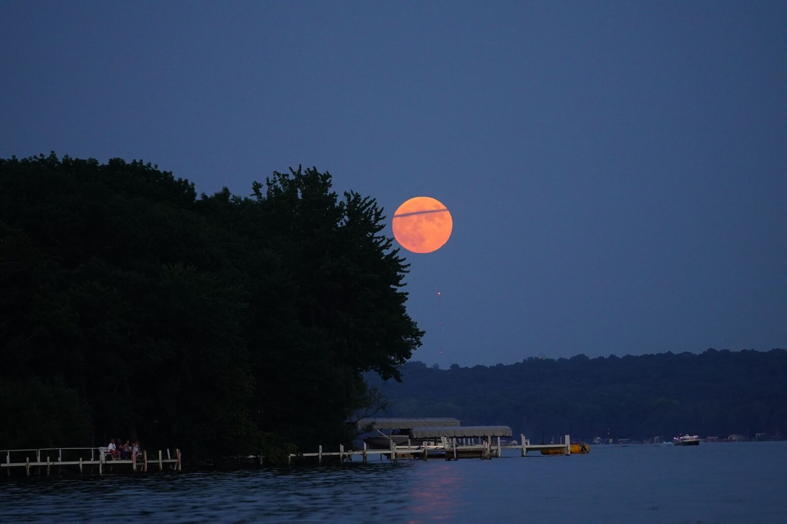 Rare strawberry moon appears over green lake, wisconsin