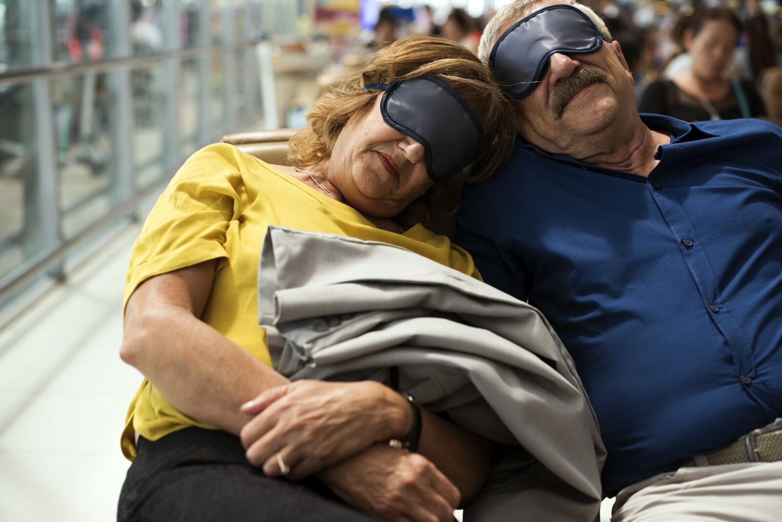older couple sleeping in airport