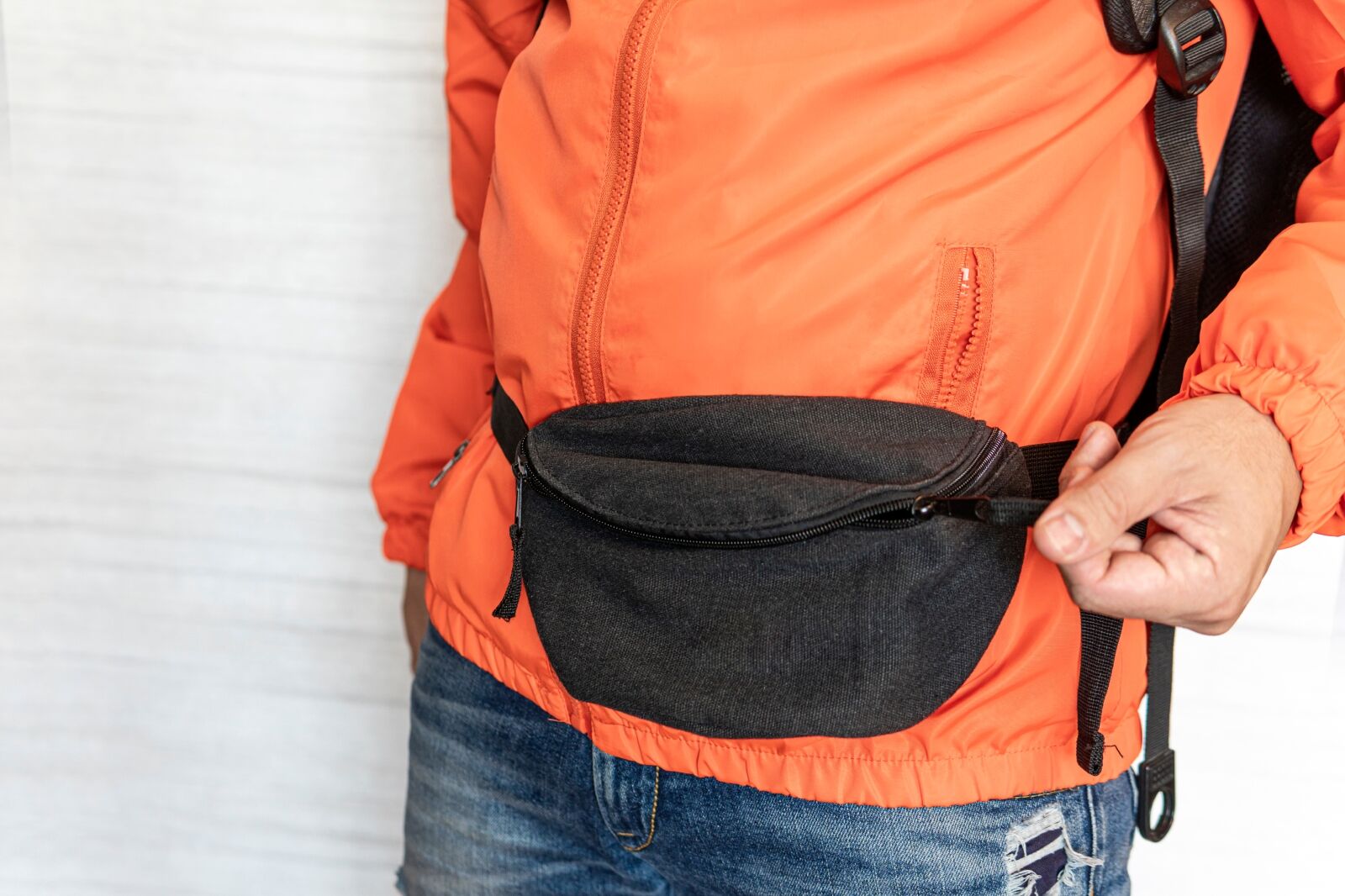 A black waist bag on the traveler's stomach. Comfortable Fashionable Travel Belt Bag