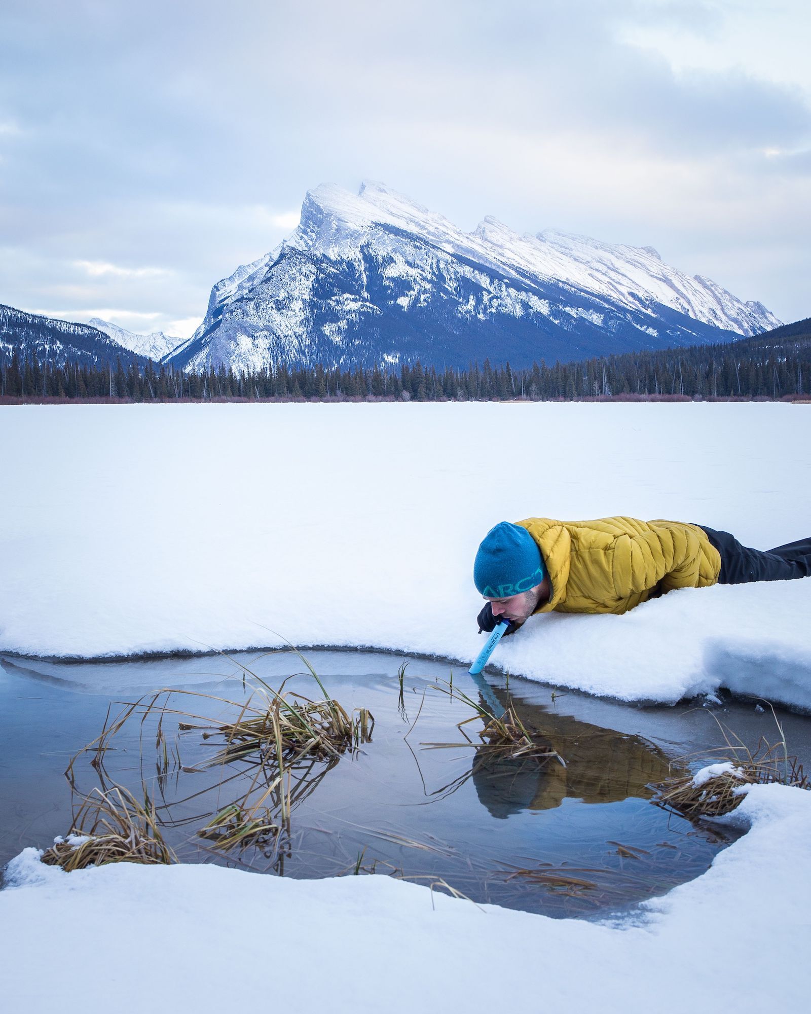 person drinking from arctic lake