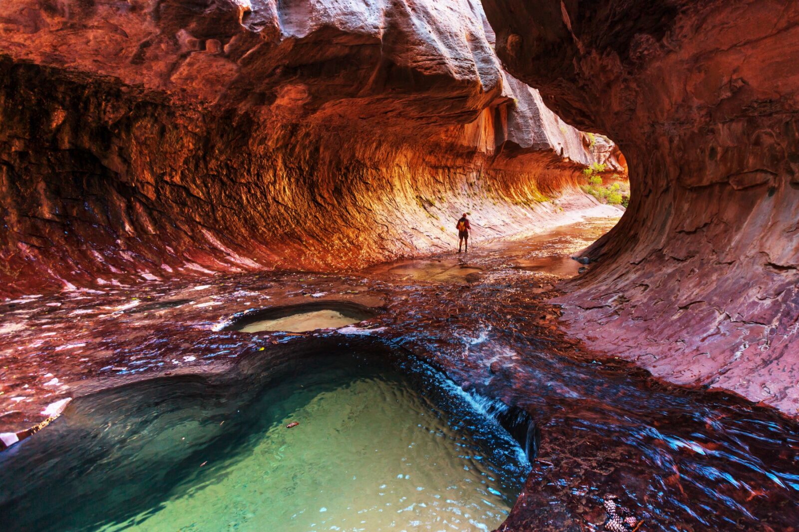 a hiker in the narrows in zion national park