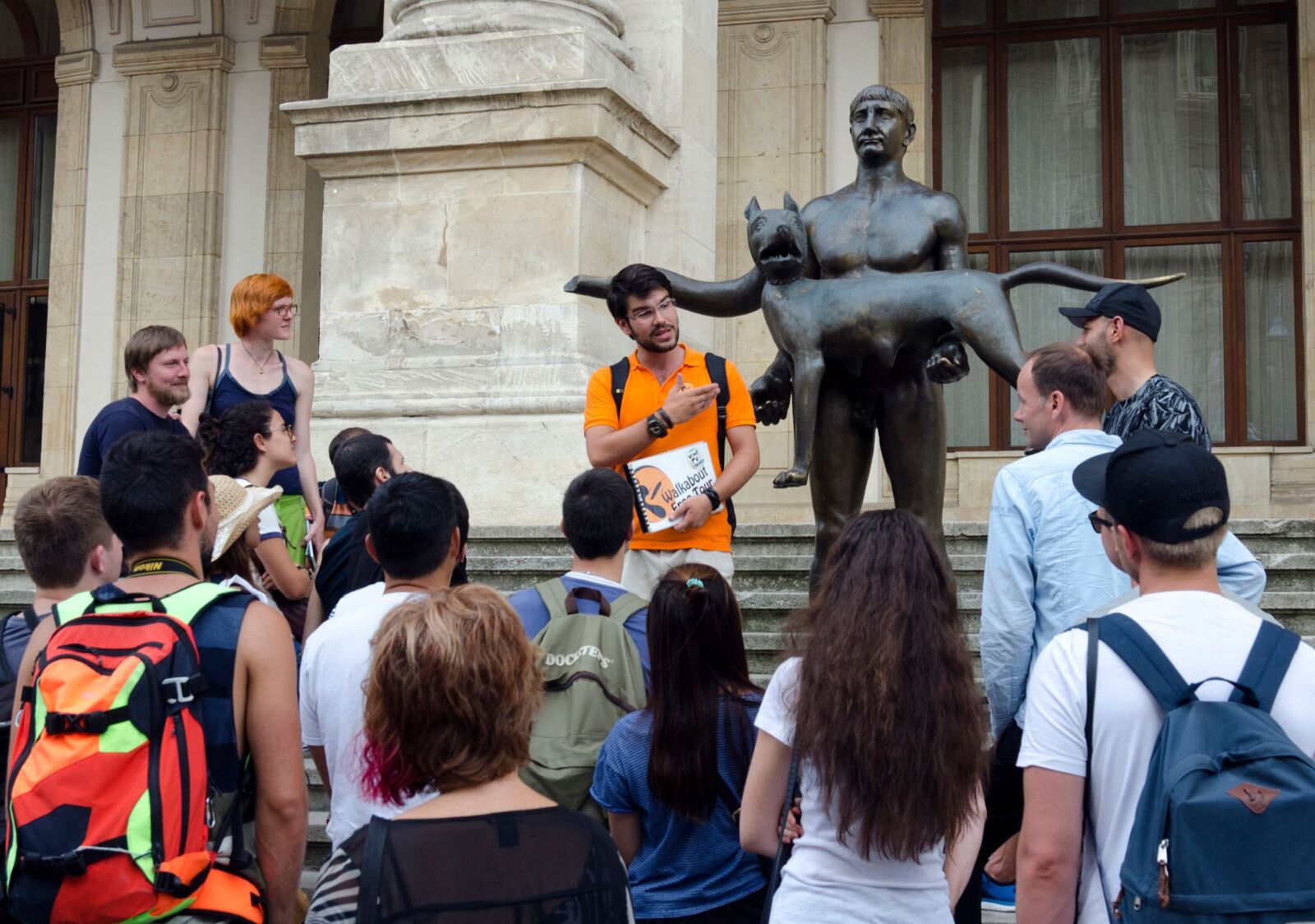 young guide speaking in front of a musuem on a free walking tour