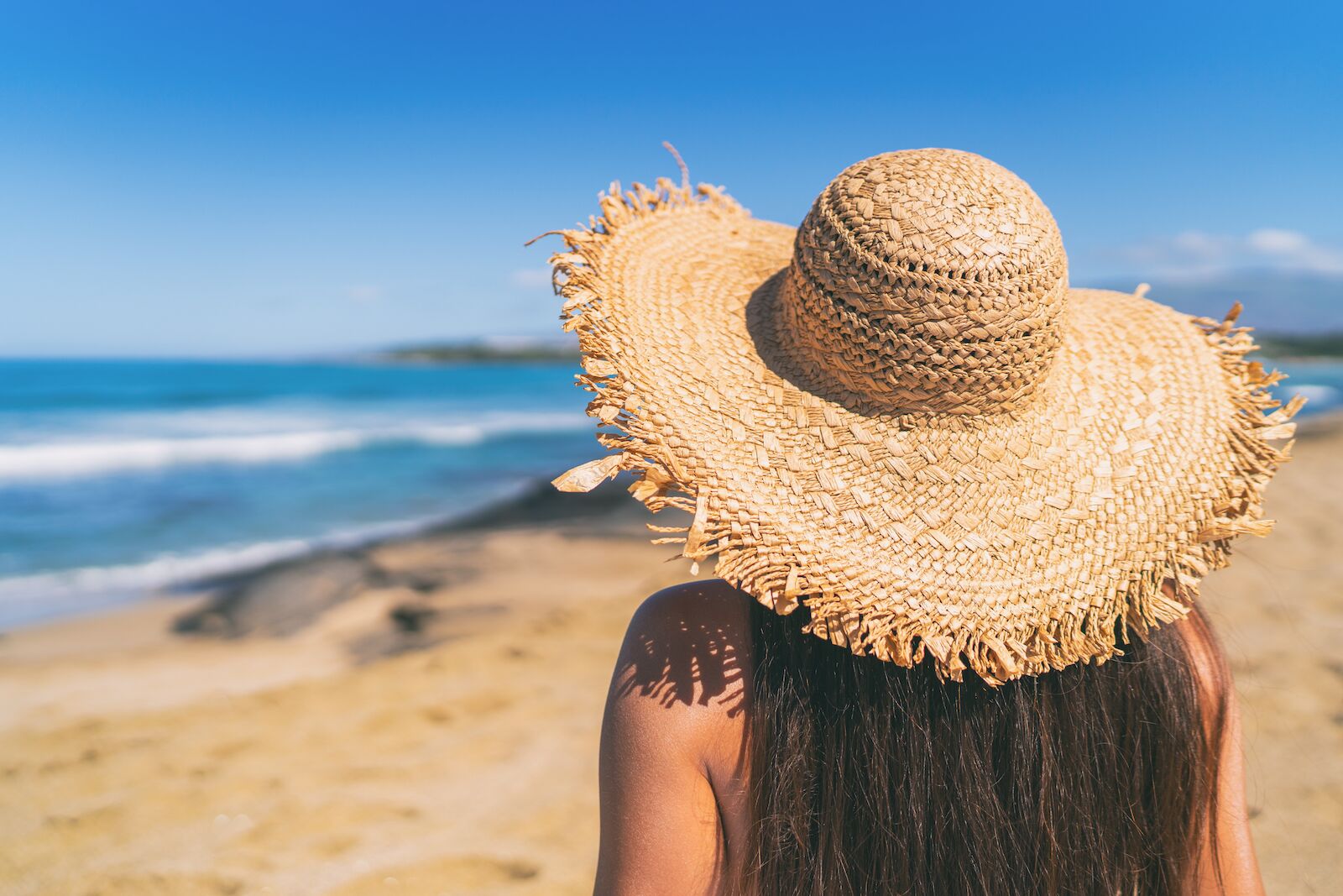 Woman wearing a sun hat on the beach in Hawaii
