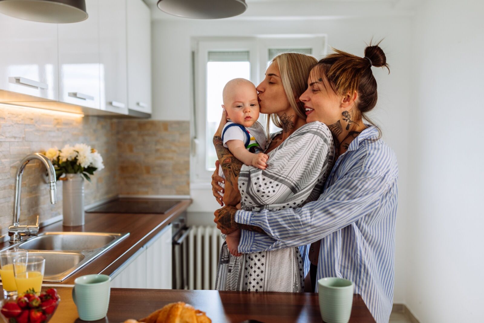 young couple with baby in kitchen 