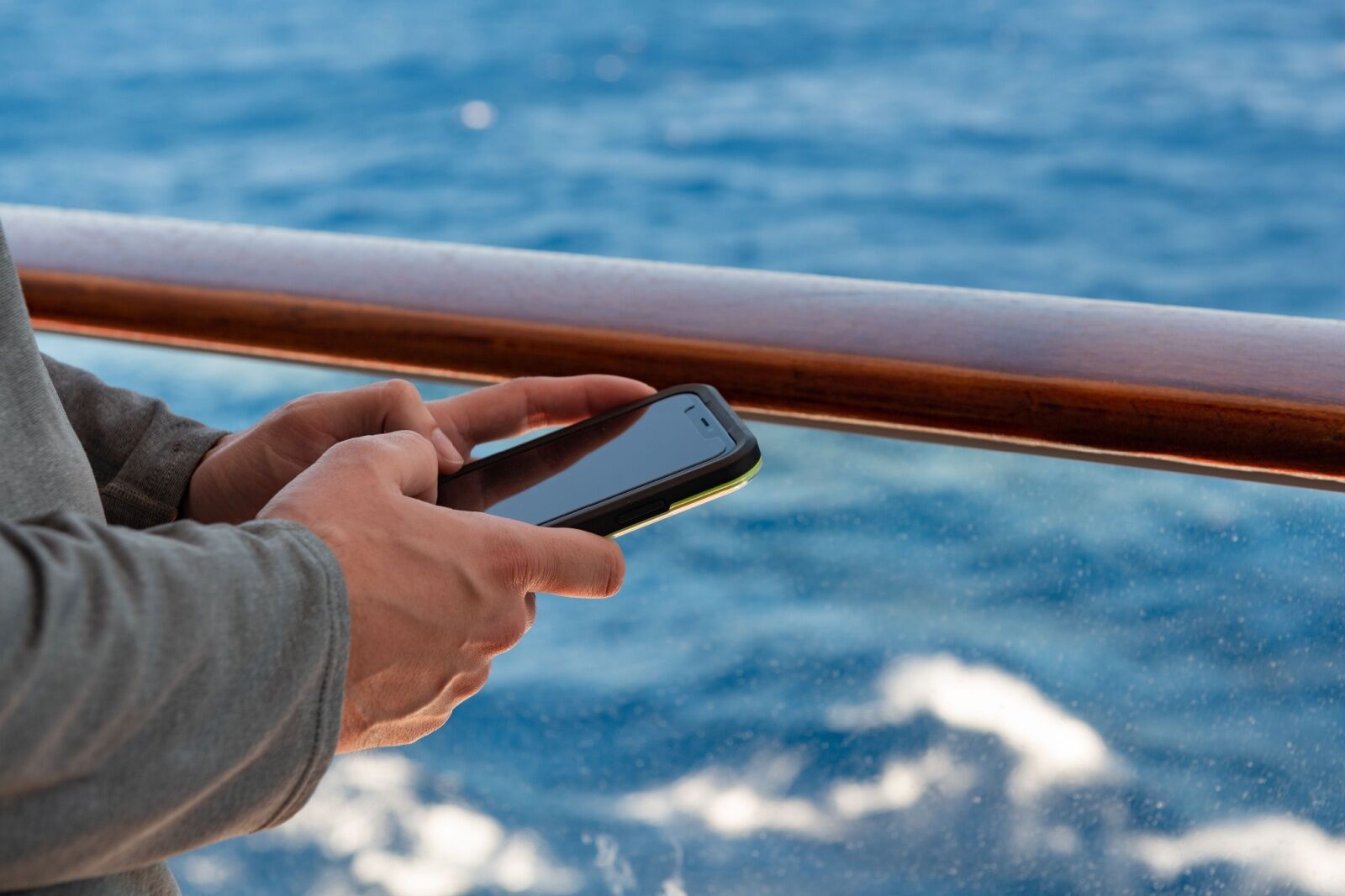 hands at sea holding a mobile phone